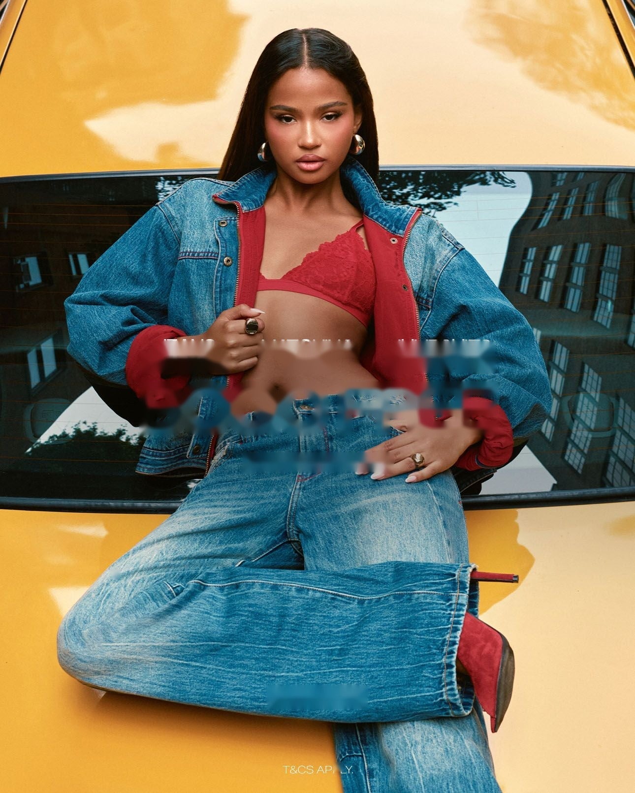 Femme en veste et jean en denim posant sur une voiture jaune pour l'opération 1 acheté = 1 offert sur les jeans, ensembles et combinaisons.